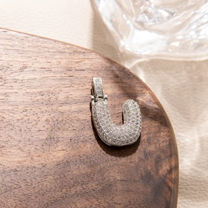 Detailed macro shot of a silver letter U pendant featuring micro-pave cubic zirconia