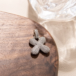 Macro shot of micro-pave cubic zirconia letter X pendant with silver hip-hop finish