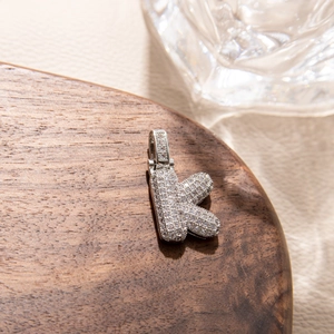 Macro shot of silver bubble letter K pendant with micro-paved cubic zirconia stones
