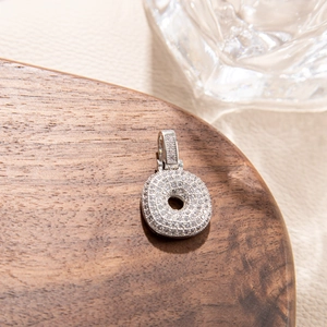 Macro detail of high-quality pavé cubic zirconia on silver-tone circular donut pendant