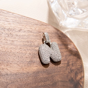 Detailed macro view of 3D bubble letter N pendant with iced out silver plating
