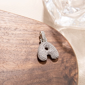 Macro detail of silver letter A pendant featuring micro-pave cubic zirconia stones