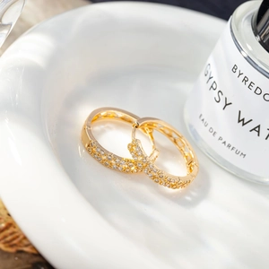 Close-up of gold hoop earrings with zircon pavé setting and hollow side patterns