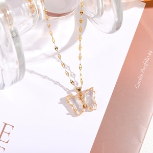 Detail eines goldenen Schmetterlingsanhängers mit klaren Flügeln und Zirkonia-Besatz