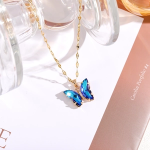 Detail des blau verläuften Kristall-Schmetterlingsanhängers an einer Goldkette