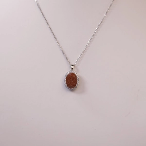 Vintage style necklace featuring oval brown sandstone pendant with shimmering crystals