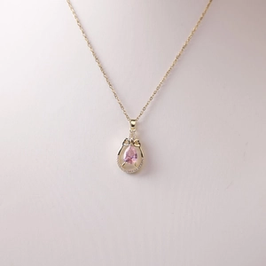 Elegant gold necklace with a pink pear-shaped gemstone pendant and white micro-diamonds