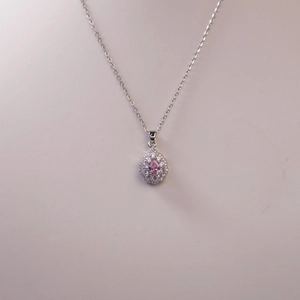 Detailed view of a pear-shaped pink gemstone necklace with white diamond halo setting