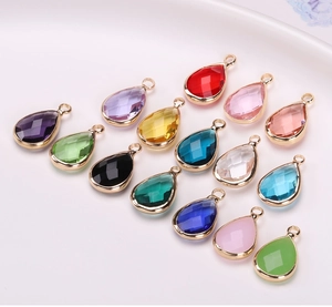 Détails macro des pendentifs en goutte facettés multicolores avec monture dorée