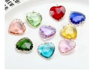 Macro shot of colorful heart-shaped crystal pendants with gold edges in nine different colors