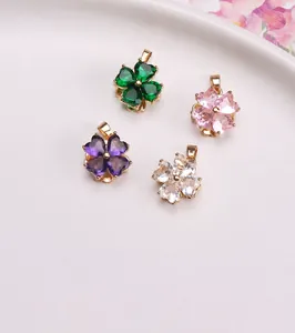 Dettaglio macro di ciondoli a quadrifoglio in zirconia nei colori verde, rosa e viola