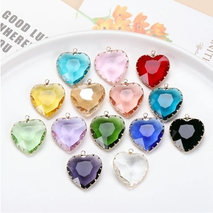 Collection of colorful heart-shaped crystal charms with gold edges on white plate