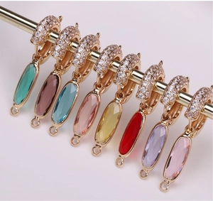 Detail of faceted oval crystal charms with gold plating and sparkling stone inlay