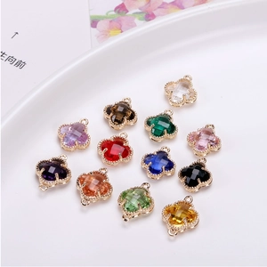 Macro detail of twelve colorful crystal clover pendants with gold beaded edges for DIY jewelry