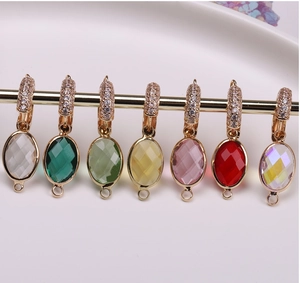 Macro view of oval crystal connector pendants with cubic zirconia and gold plating