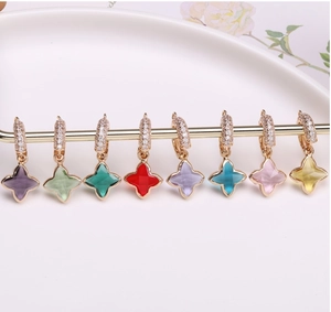 Détail macro de boucles d'oreilles trèfle plaquées or avec cristaux et zircons colorés