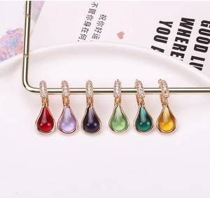 Detailed close-up of water drop jewelry pendants with gold plating and colorful gemstones