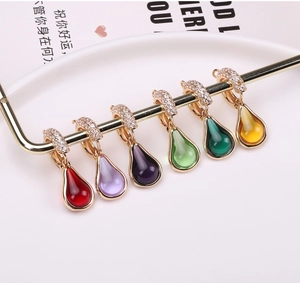 Close-up of colorful teardrop pendants with gold-plated edges and sparkling zircon inlay