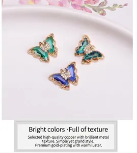 Detail showing crystal butterfly pendants in emerald, teal, and blue with gold plating