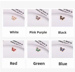 Detailed grid view of crystal butterfly pendants in six colors on a white ceramic tray