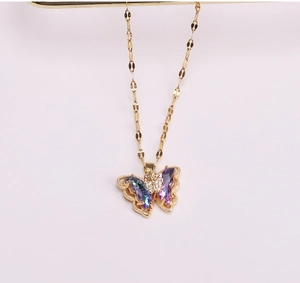Macro shot of iridescent crystal butterfly pendant on a delicate gold metal chain