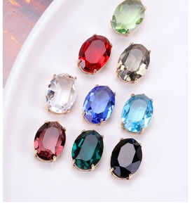 Detail view of 9 multi-colored faceted crystal pendants with gold claw settings