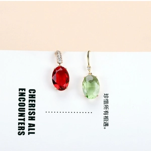Macro detail of oval crystal drop earrings with gold-plated hooks and pave-set zircons