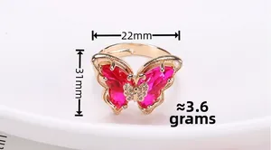 Macro shot of 18K gold butterfly ring with rose red crystals and diamond accents