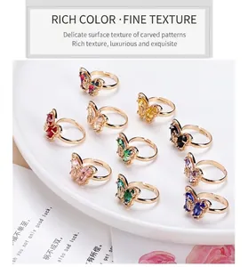 Detailed close-up of crystal butterfly rings in multiple colors with 18K gold plating