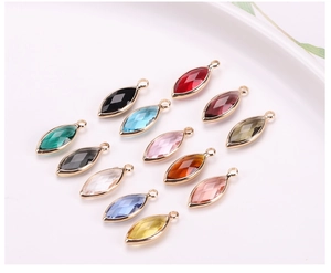 Detailed macro view of twelve colorful marquise glass crystal charms with gold plated borders