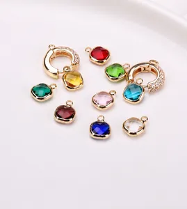 Detail view of colorful faceted square crystal charms with gold-plated copper frames