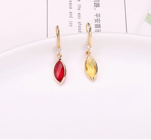 Detail of gold-plated marquise cut crystal drop earrings with red and yellow gemstones