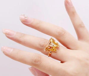 Detailed macro view of butterfly ring with yellow pear-cut stones and rose gold finish