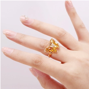 Detail showing crystal butterfly ring in rose gold finish on model finger