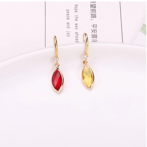 Detailed view of red and yellow horse-eye crystal pendants on gold-plated ear hooks