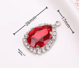 Vista macro di un ciondolo a goccia rosso 26x17mm con montatura argentata e piccoli strass