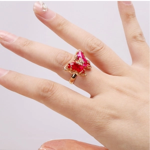 Close-up of butterfly ring with red and pink crystal stones and 18K gold band