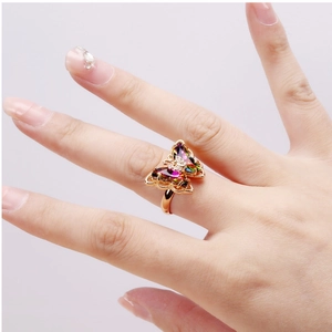 Macro view of crystal butterfly ring featuring 18K gold base and multi-color gemstones