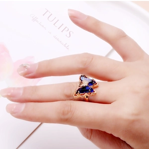 Detail of rose gold butterfly ring featuring deep blue crystals and white diamond accents