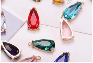Macro shot of colorful teardrop glass pendants with gold plated metal edges for DIY jewelry