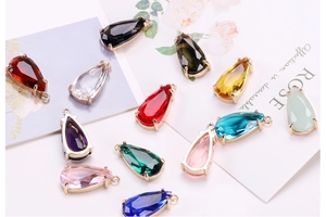 Close-up of colorful faceted crystal teardrop pendants with metal rings for jewelry making