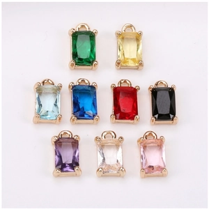 Detailed close-up of colorful rectangular crystal charms with gold-plated claw settings