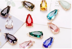 Macro shot of colorful pear-shaped crystal pendants with gold claw settings for DIY jewelry