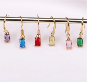 Detail of colorful rectangular crystal charms with gold hooks on a display stand