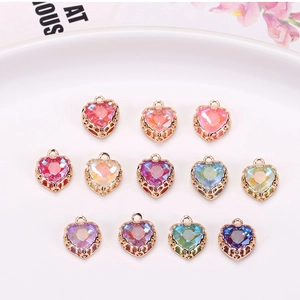 Macro shot of colorful heart crystal pendants with intricate hollow gold metal backings