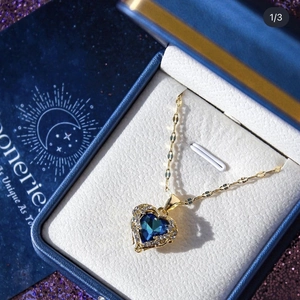 Close-up of heart-shaped blue crystal pendant necklace in a luxury blue jewelry gift box