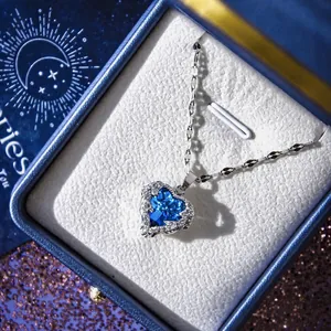 Close-up of heart-shaped blue crystal pendant necklace in a zodiac Aries jewelry gift box