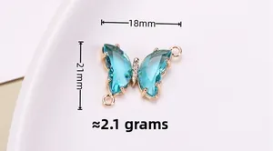 Detalle del colgante de mariposa de cristal azul claro con base oro rosa, talla 18mm x 21mm
