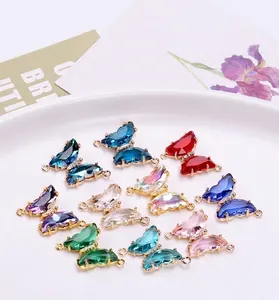 Detalle de dijes de mariposa de cristal coloridos con marco dorado para joyería DIY
