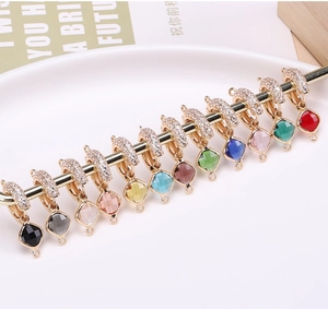 Macro shot of colorful square crystal pendants with gold-plated zircon connectors set
